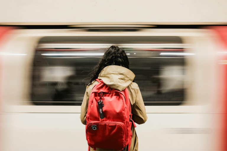Ragazza con zaino davanti a un treno in corsa, metafora di comunicare nel materno infantile e responsabilità digitale