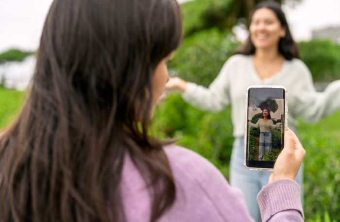 Due amiche e un cellulare come metafora della condivisione da parte di parenti e familiari nello sharenting